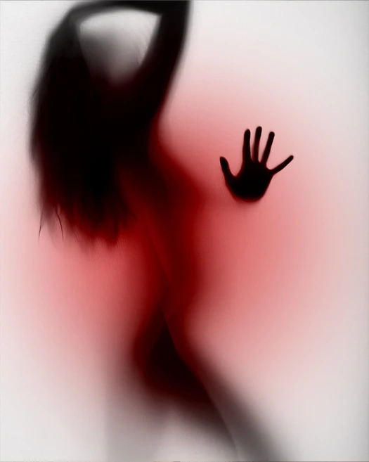 Photo d’une femme derrière une vitre givrée.